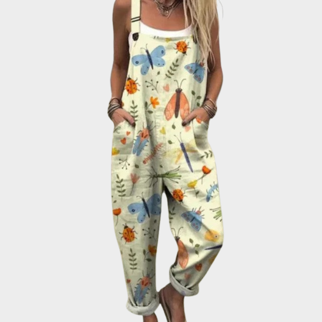 Woman wearing cream dungarees printed with painterly butterflies, ladybirds and fine leafy sprigs