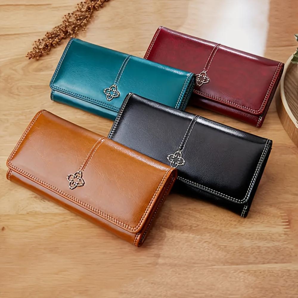 A woman holding an open bifold wallet, tucking a card into its slot.