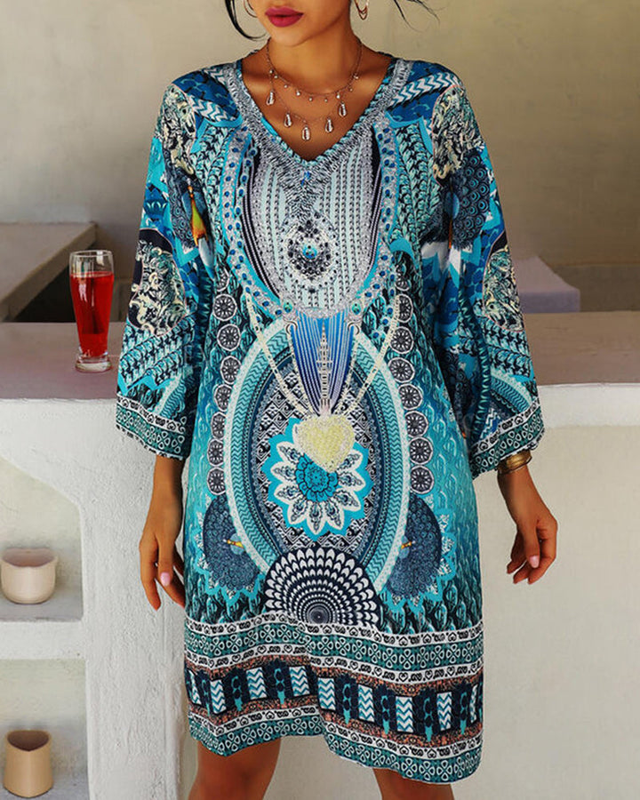 Woman wearing the Celia boho print dress with bell sleeves, smiling outdoors on a bright day.