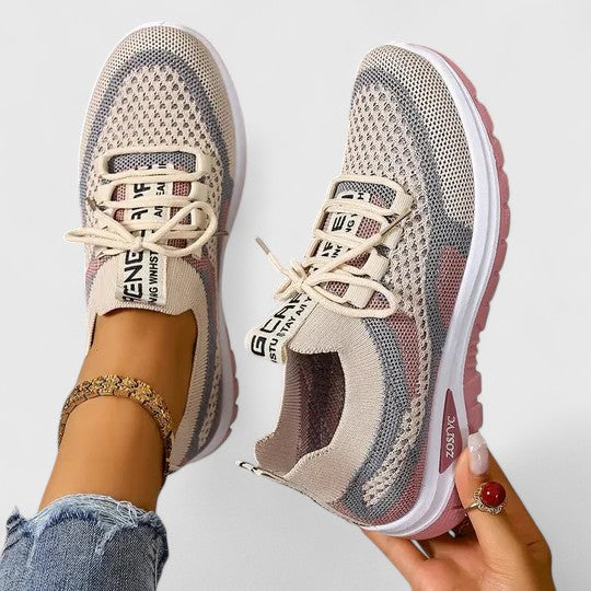 A woman lacing up light, breathable orthopaedic trainers before a walk.
