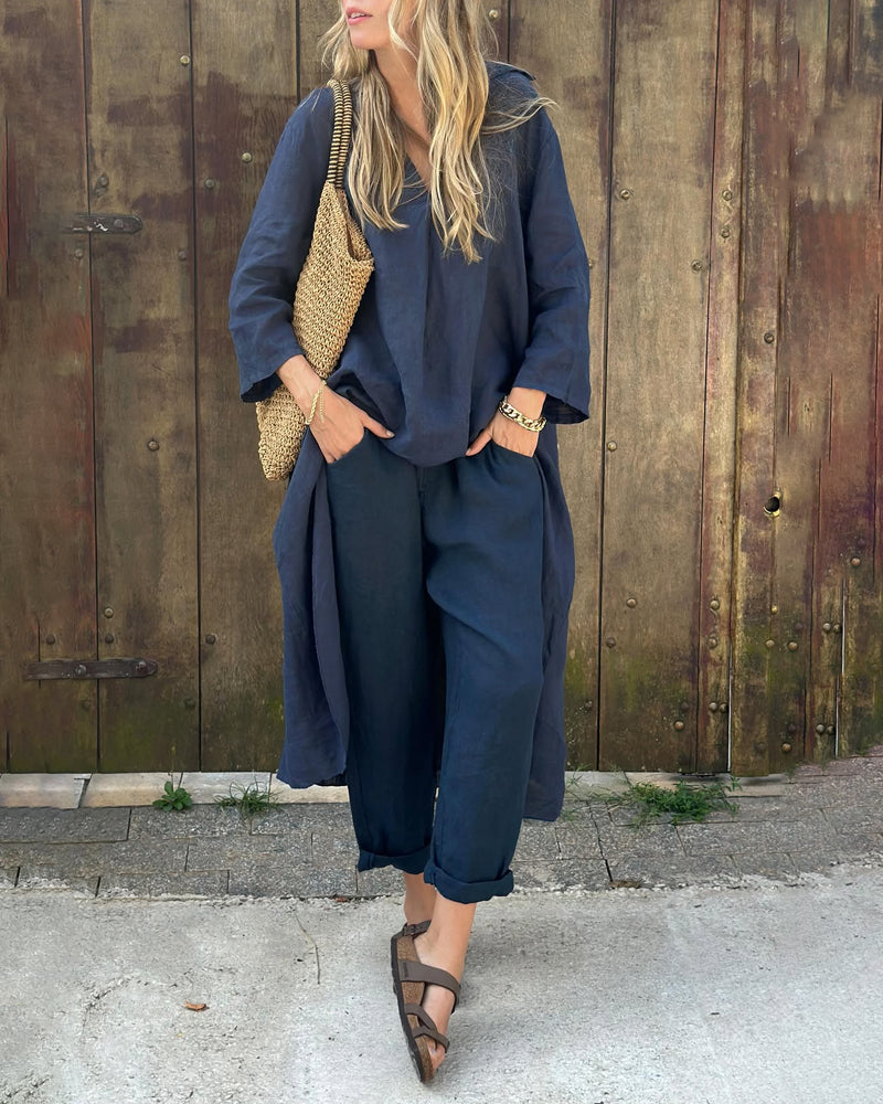 A woman wearing a blue asymmetric tunic with wide-leg trousers