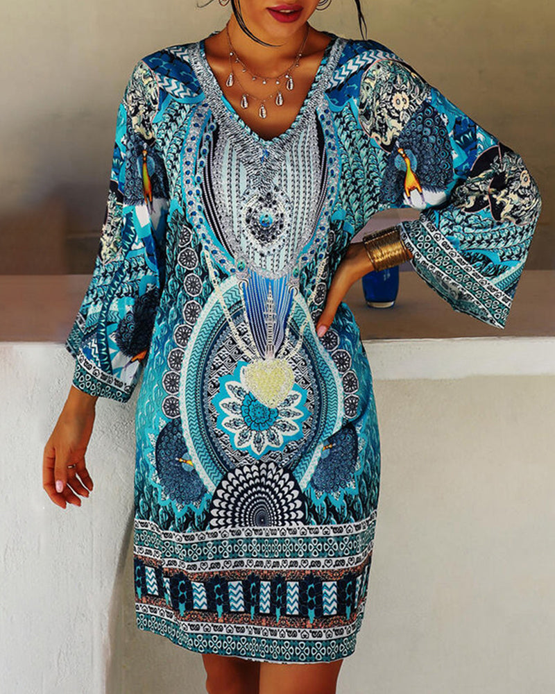 Woman wearing the Celia boho print dress with bell sleeves, smiling outdoors on a bright day.