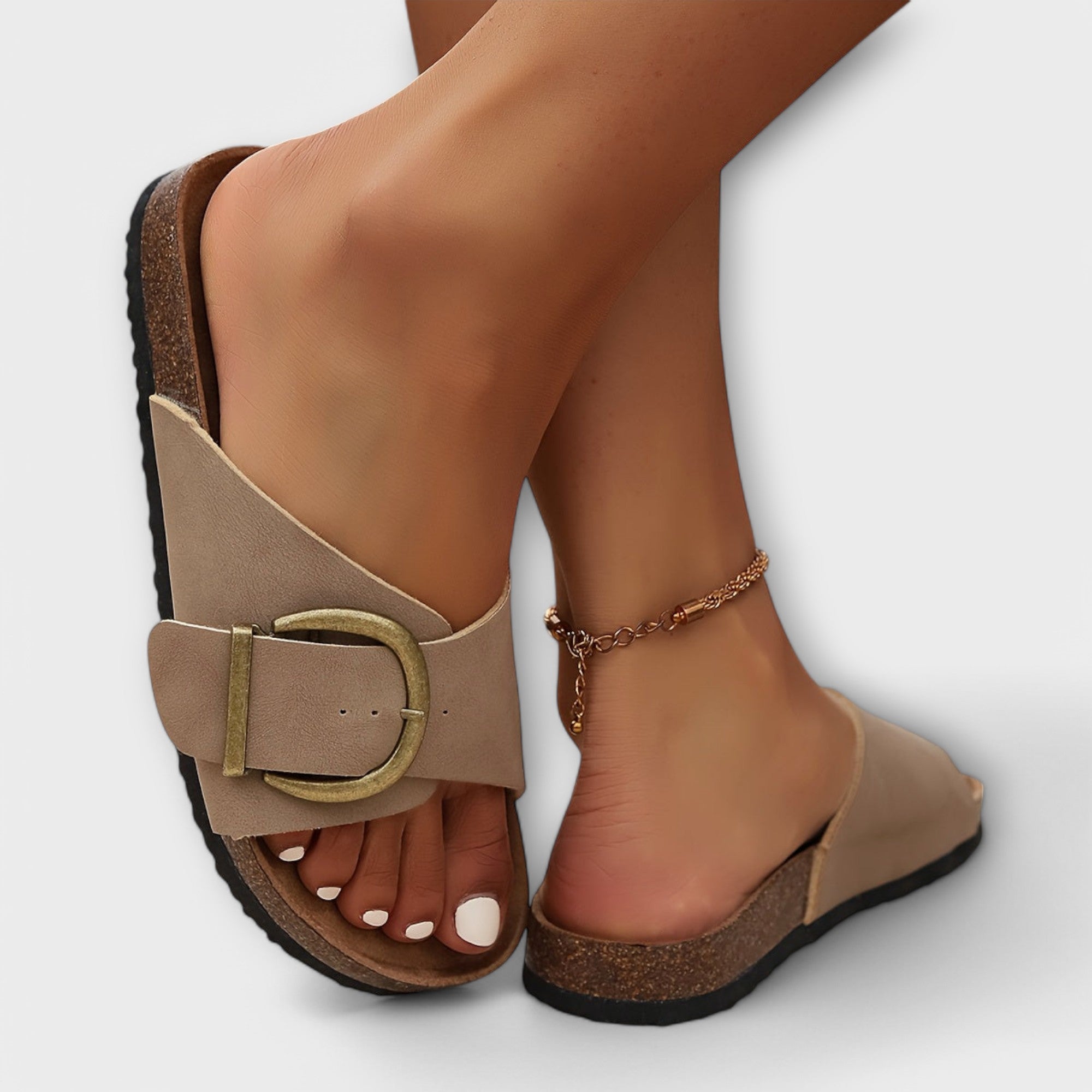Black flat sandals with wide strap and decorative buckle detail