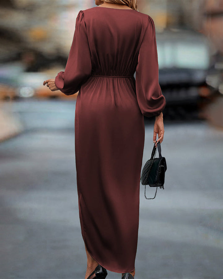 Woman in the Naomi draped evening dress with long sleeves and a softly gleaming finish, ready for an elegant night out.