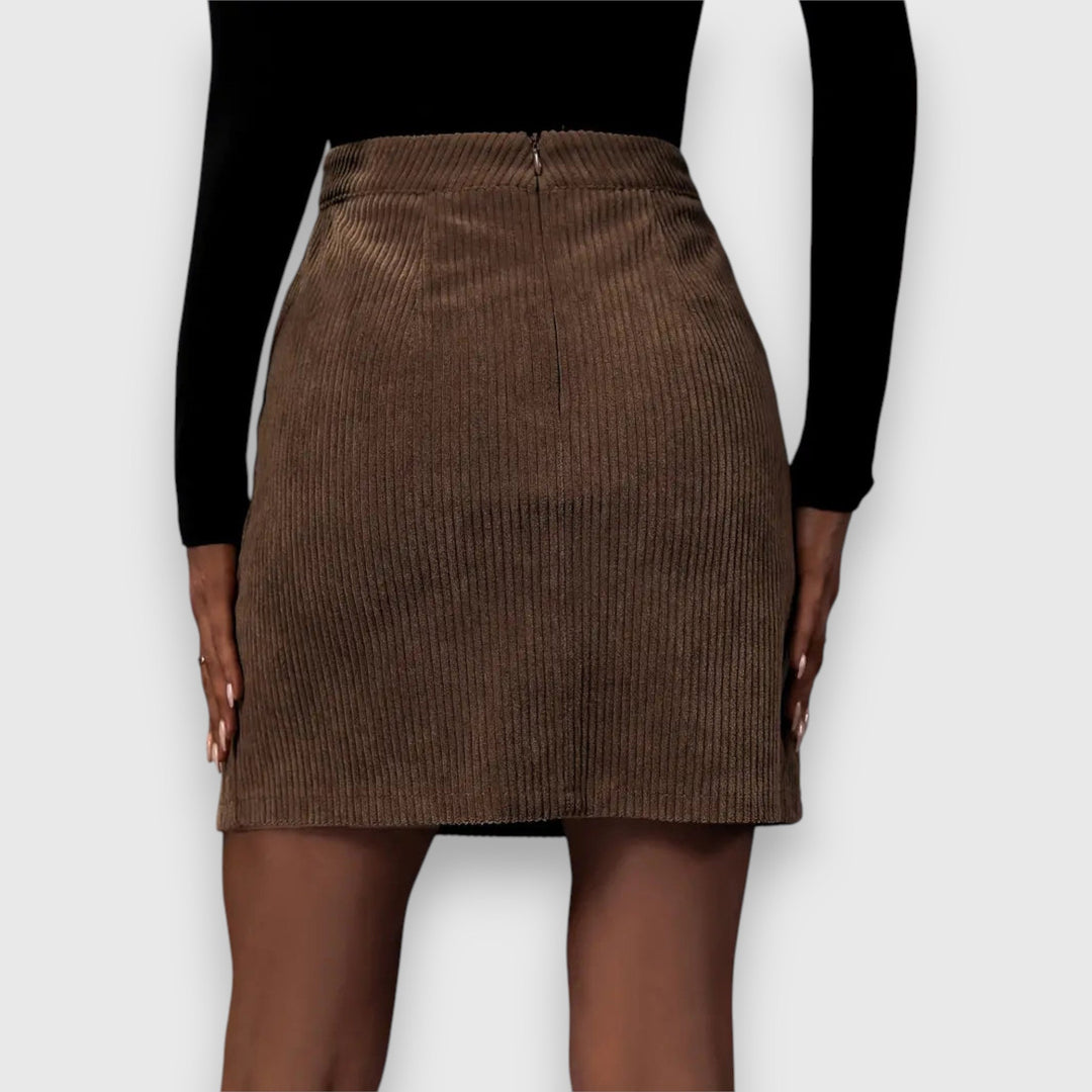 A woman in a textured ribbed skirt with a front slit, styled with a jumper for a relaxed autumn look.
