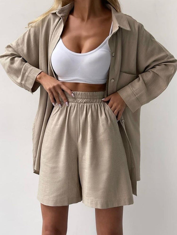 A woman wearing an oversized button-up shirt with matching high-waisted shorts.