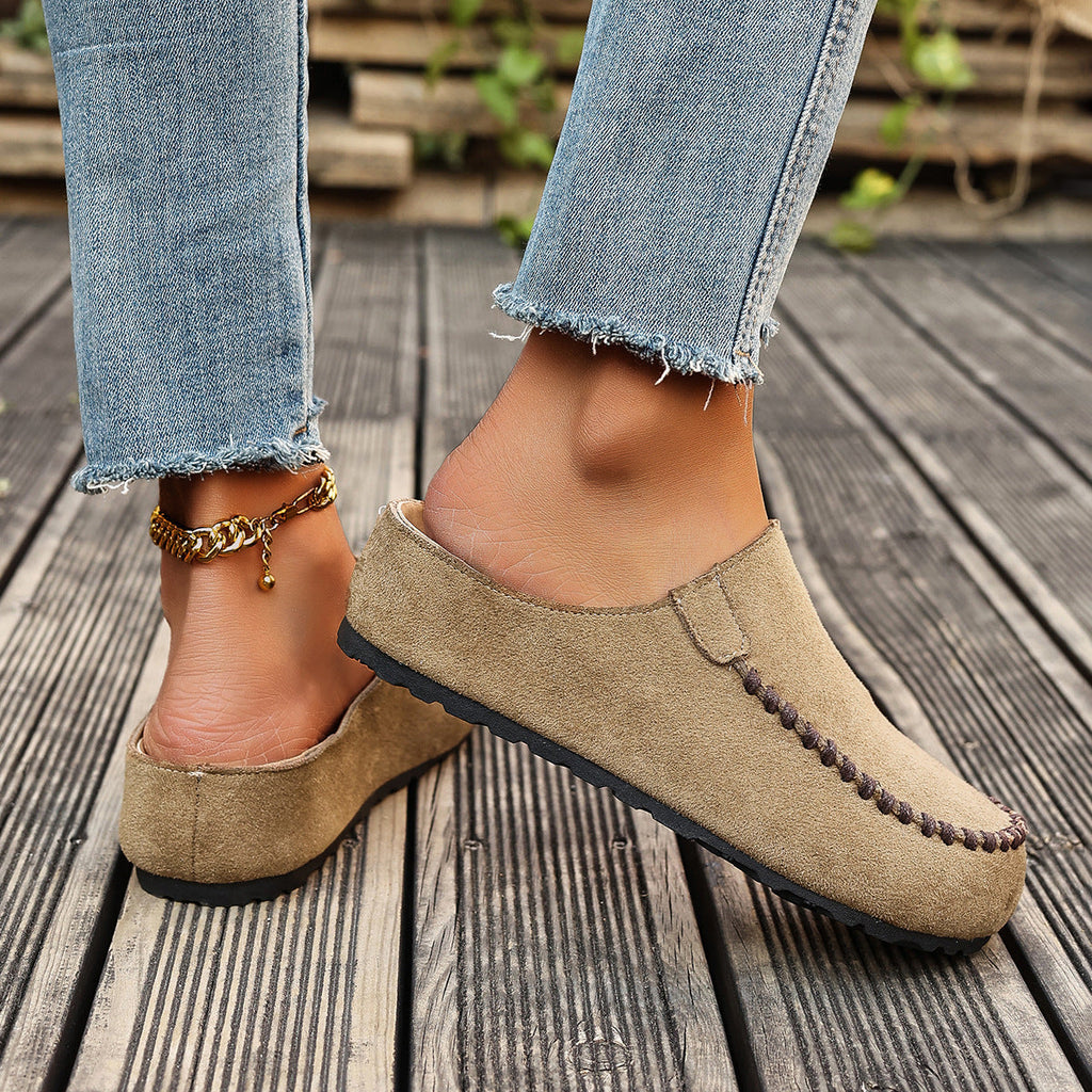A pair of minimal slip-on loafers in warm brown with a soft footbed and open back