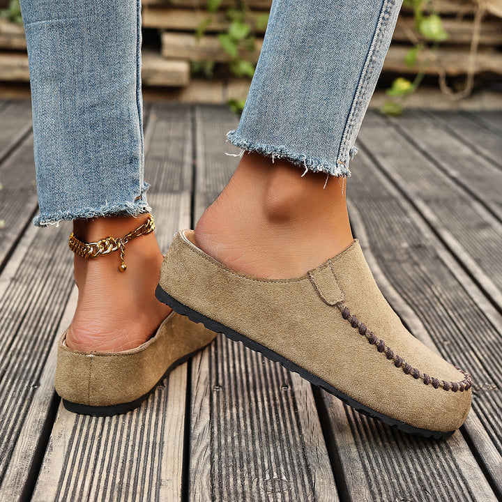A pair of minimal slip-on loafers in warm brown with a soft footbed and open back