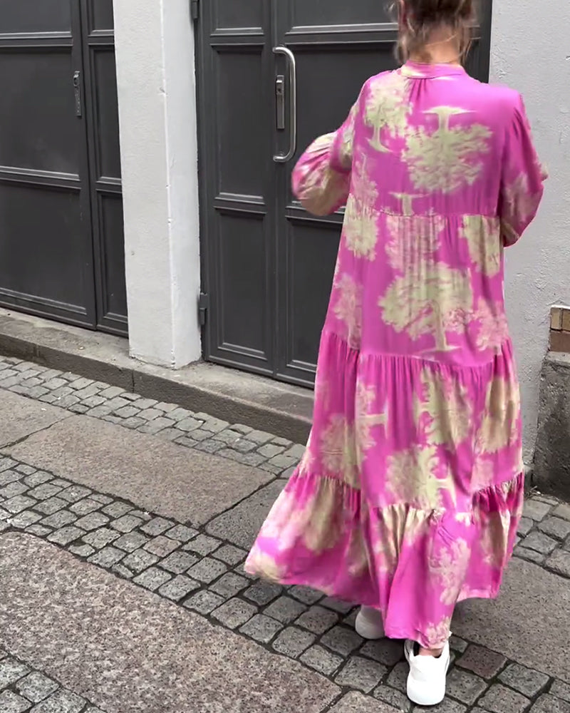Woman wearing the Abigail flowing maxi dress with a delicate print and V-neckline, the skirt moving softly as she walks.