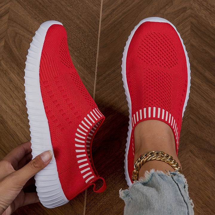 A woman slipping on ultralight sock-style trainers that hug the foot.