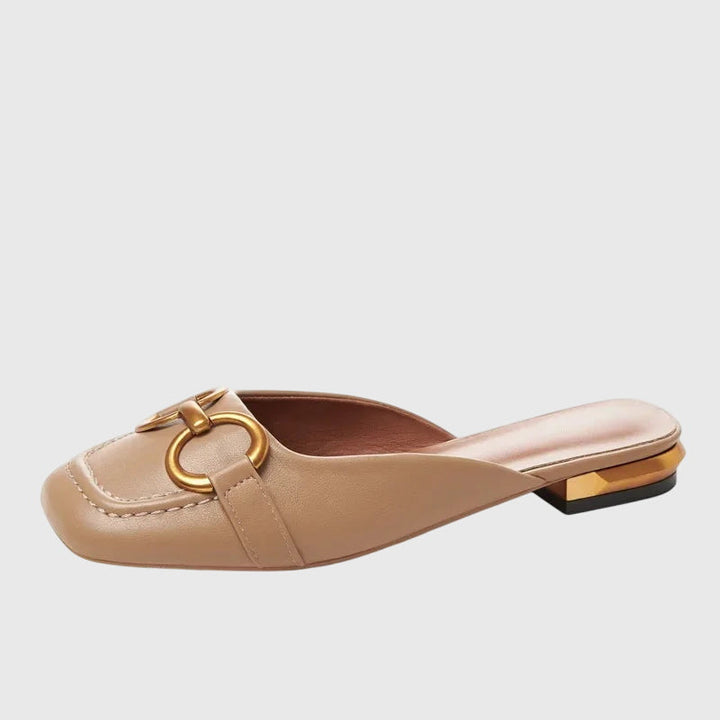 A woman walking easily in beige everyday support sandals with a broad, cushioned footbed.