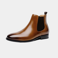 Men's brown classic dress boots with a smooth refined upper and structured silhouette on a neutral background