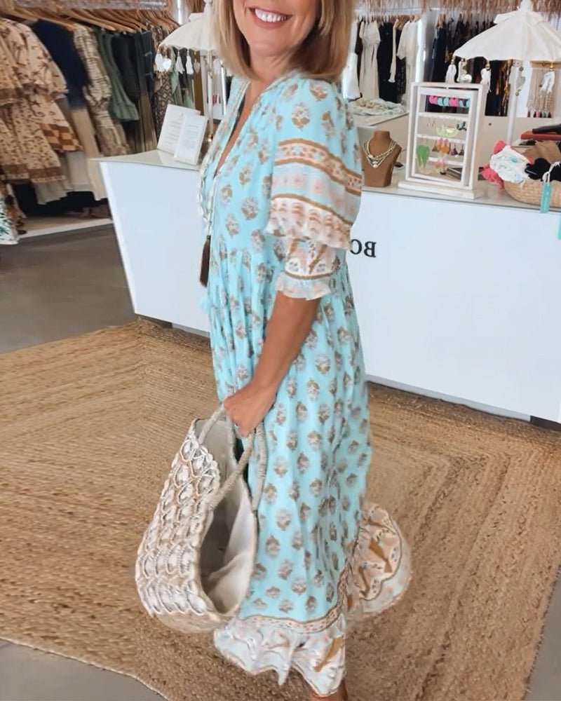 A woman wearing the Patricia boho floral midi dress with a fringed neckline and ruffled skirt.