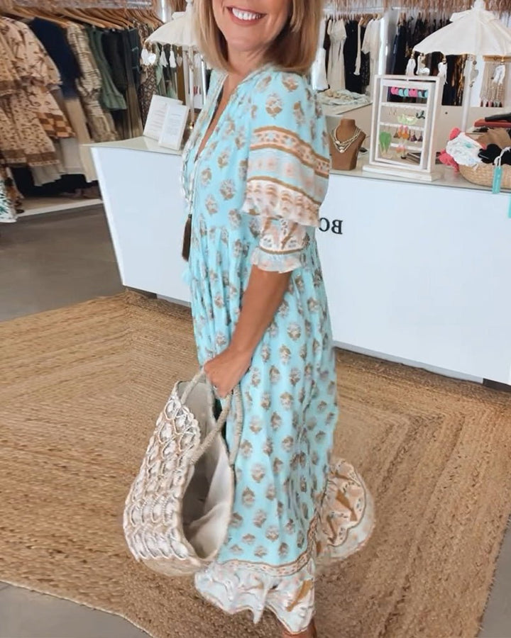 A woman wearing the Patricia boho floral midi dress with a fringed neckline and ruffled skirt.