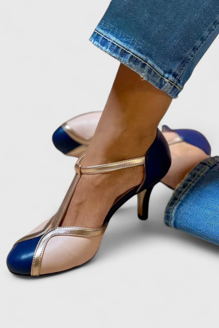 A woman wearing caramel T-strap heels, walking with grace and confidence.