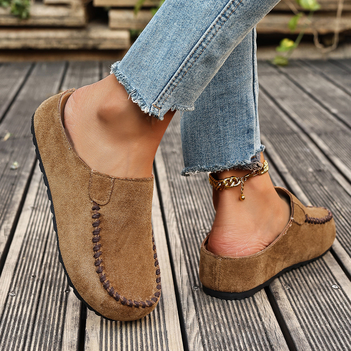 A pair of minimal slip-on loafers in warm brown with a soft footbed and open back
