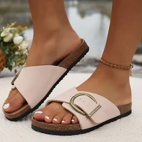 Black flat sandals with wide strap and decorative buckle detail