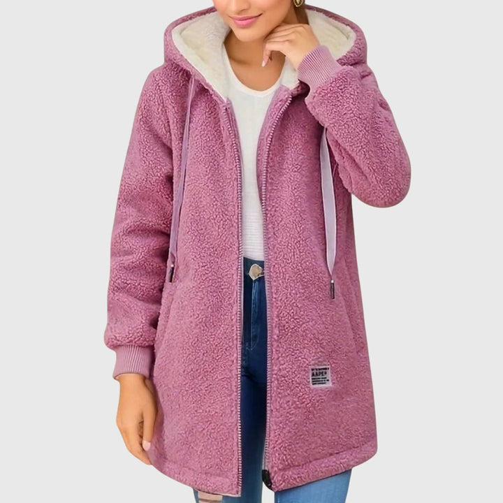 A woman wearing a cosy hooded jacket wrapped up warm on a cold winter morning.