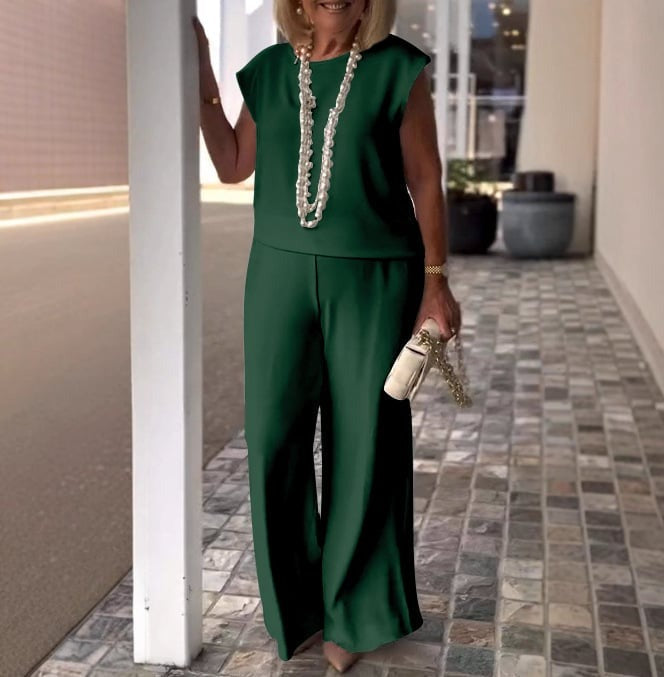 A woman wearing a flowing short-sleeve top with graceful wide-leg trousers.