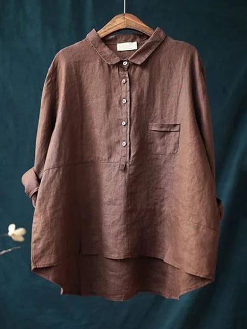 Woman wearing a flowing printed summer blouse that falls softly around her figure.