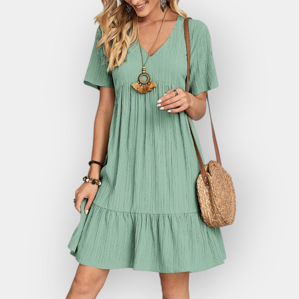 Fluid V-neck midi dress in soft sage green with a relaxed elegant silhouette
