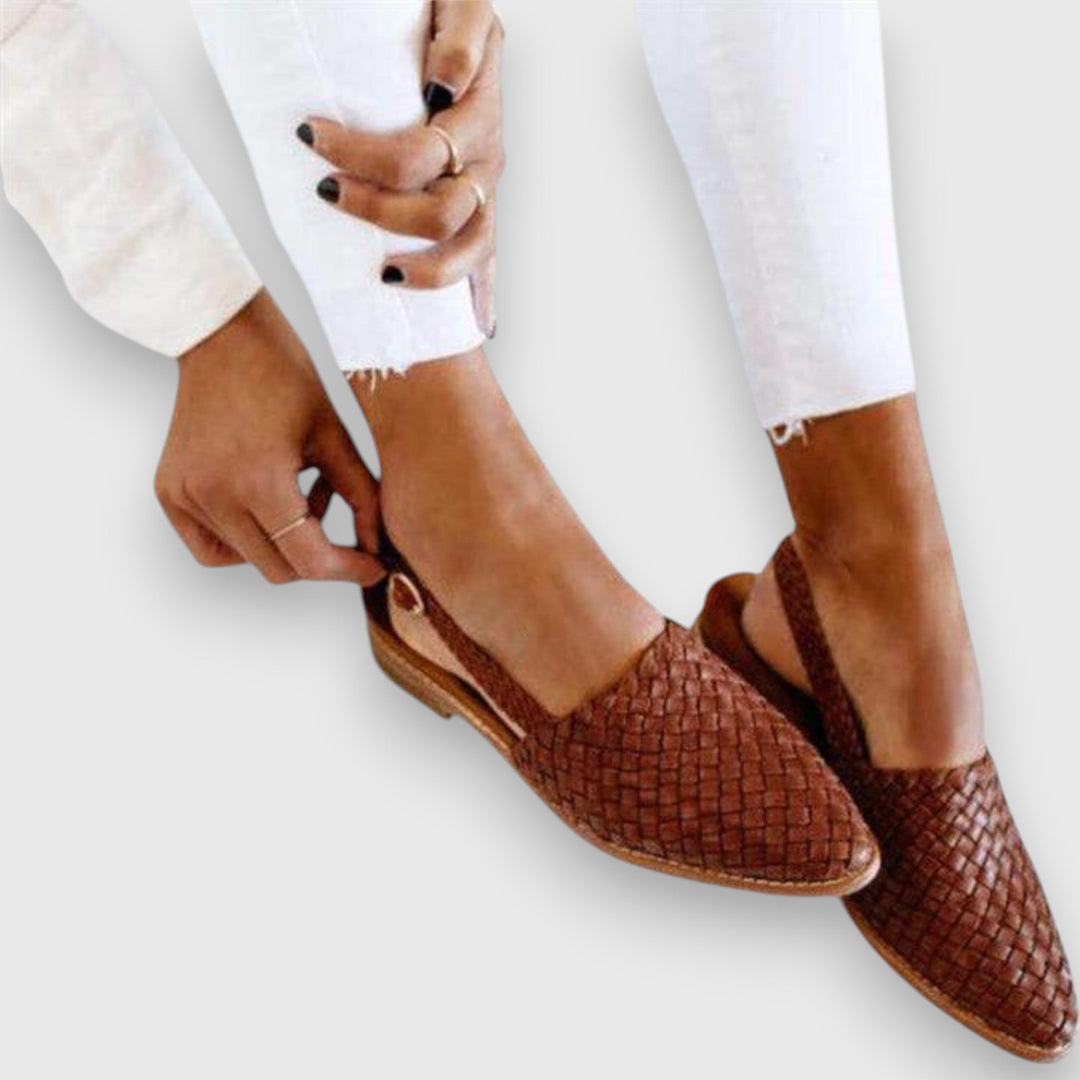 A woman wearing woven ballet flats with cropped jeans, looking relaxed and refined on a summer day.