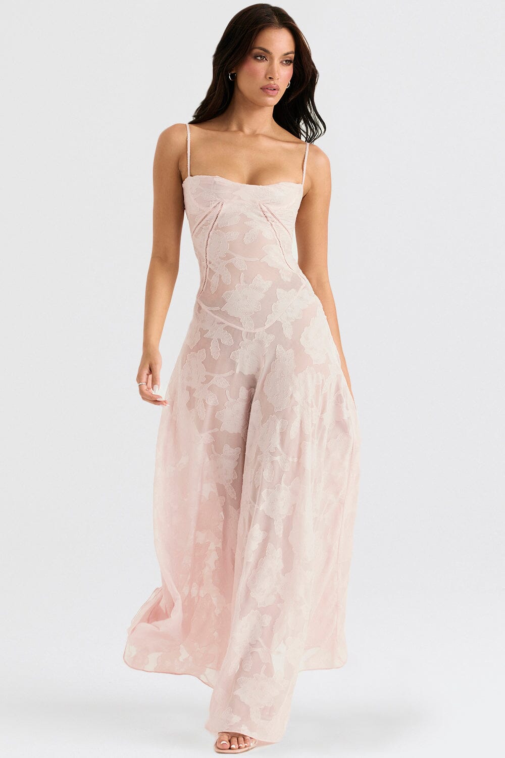 An elegant floor-length occasion dress in blush pink, styled for a formal wedding or gala event