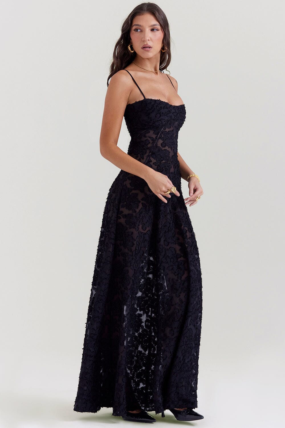 An elegant floor-length occasion dress in blush pink, styled for a formal wedding or gala event