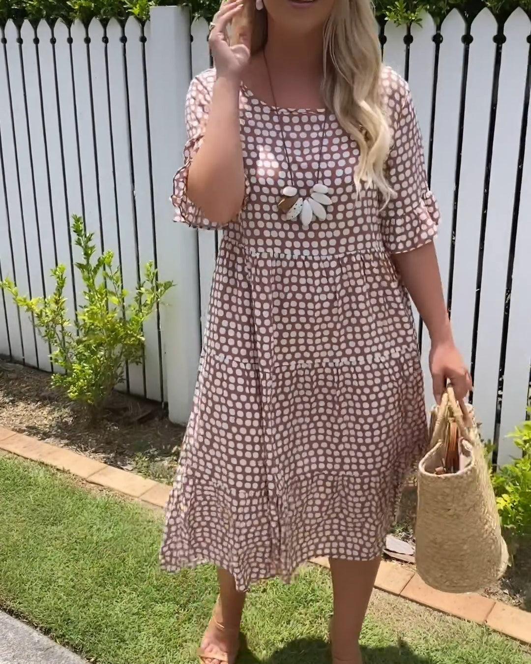 Woman wearing the Rita™ polka dot midi dress with short sleeves, relaxed and smiling in a summer setting.