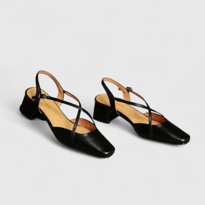 A woman wearing beige chic block heel sandals with an adjustable strap at an evening event.