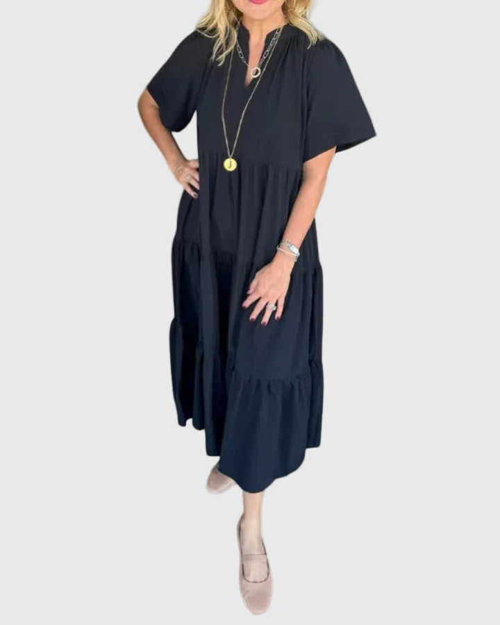 Woman wearing the Kate maxi dress with her hands resting in its side pockets.