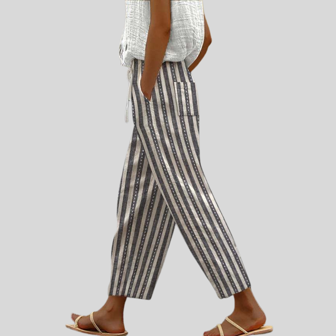 A woman wearing navy-and-cream vertical striped trousers with an elastic waist and side pocket.