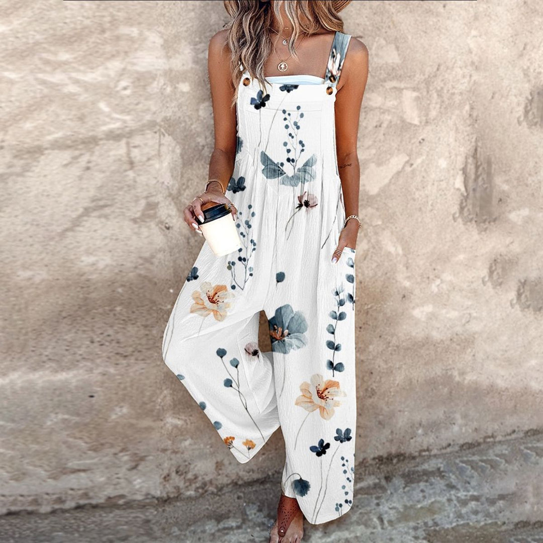 A woman wearing elegant black dungarees with a single large cream bloom and adjustable straps.