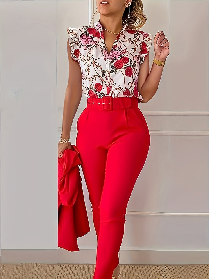 A woman wearing a floral ruffle-sleeve top with high-waisted trousers, elegant and striking.