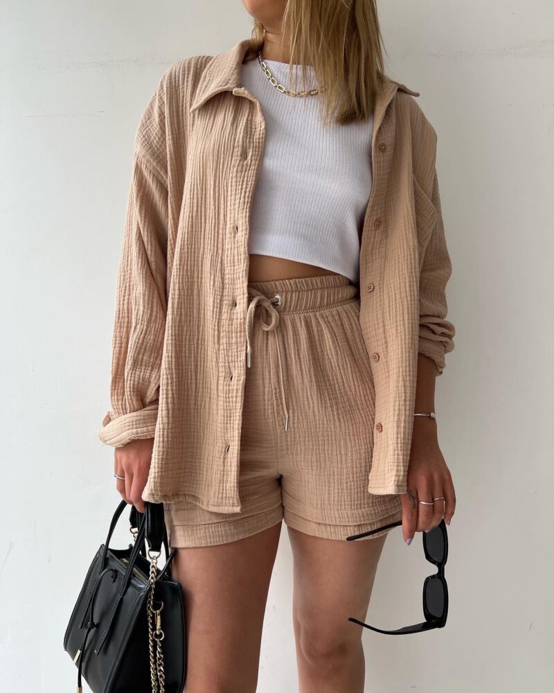 A woman wearing a soft V-neck blouse with matching playful shorts, fresh and relaxed.
