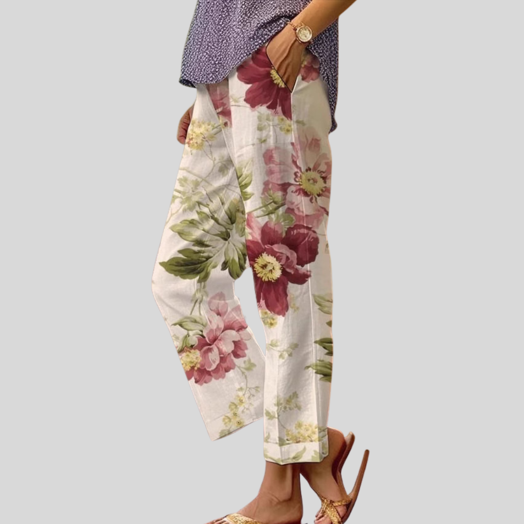 Woman wearing relaxed everyday trousers with a soft blouse and sandals at home.