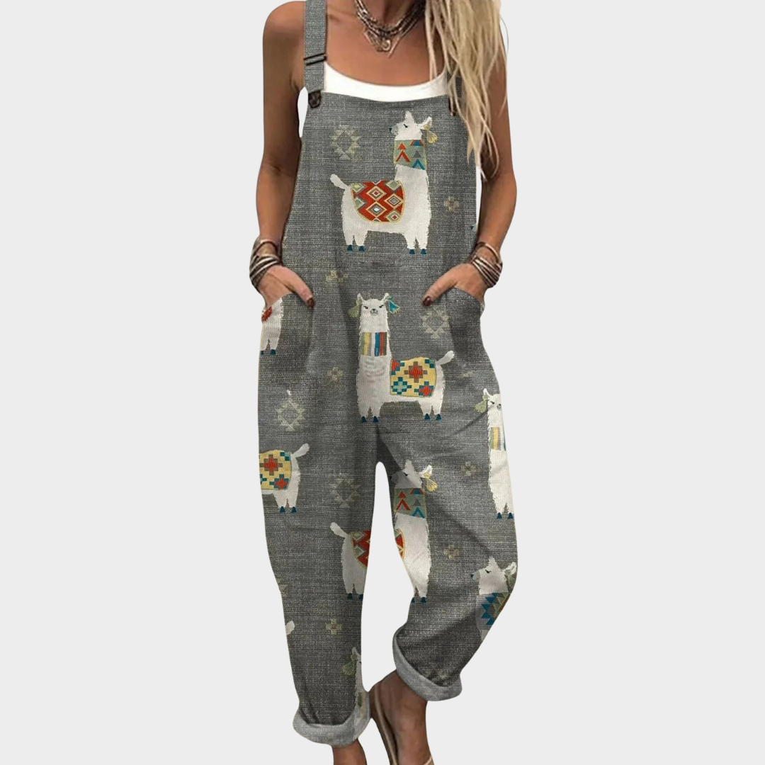 Woman wearing soft grey dungarees with a playful colourful llama print and adjustable straps