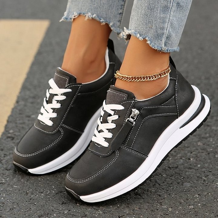 A woman wearing cushioned orthopaedic trainers with a side zip