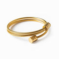 Twisted gold bracelet in gold and silver tones on a plain background