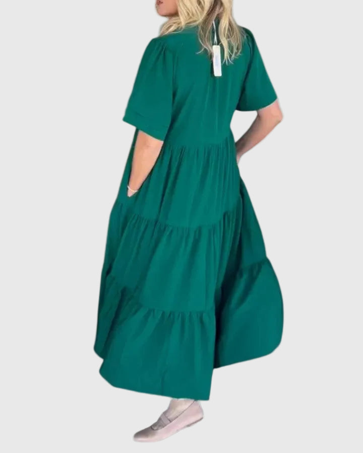 Woman wearing the Kate maxi dress with her hands resting in its side pockets.