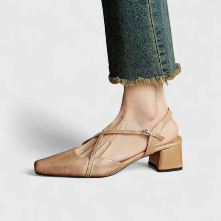 A woman wearing beige chic block heel sandals with an adjustable strap at an evening event.