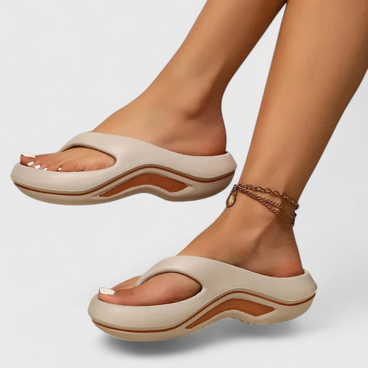 A woman in white slip-on sandals stepping out lightly, feet cushioned and supported.