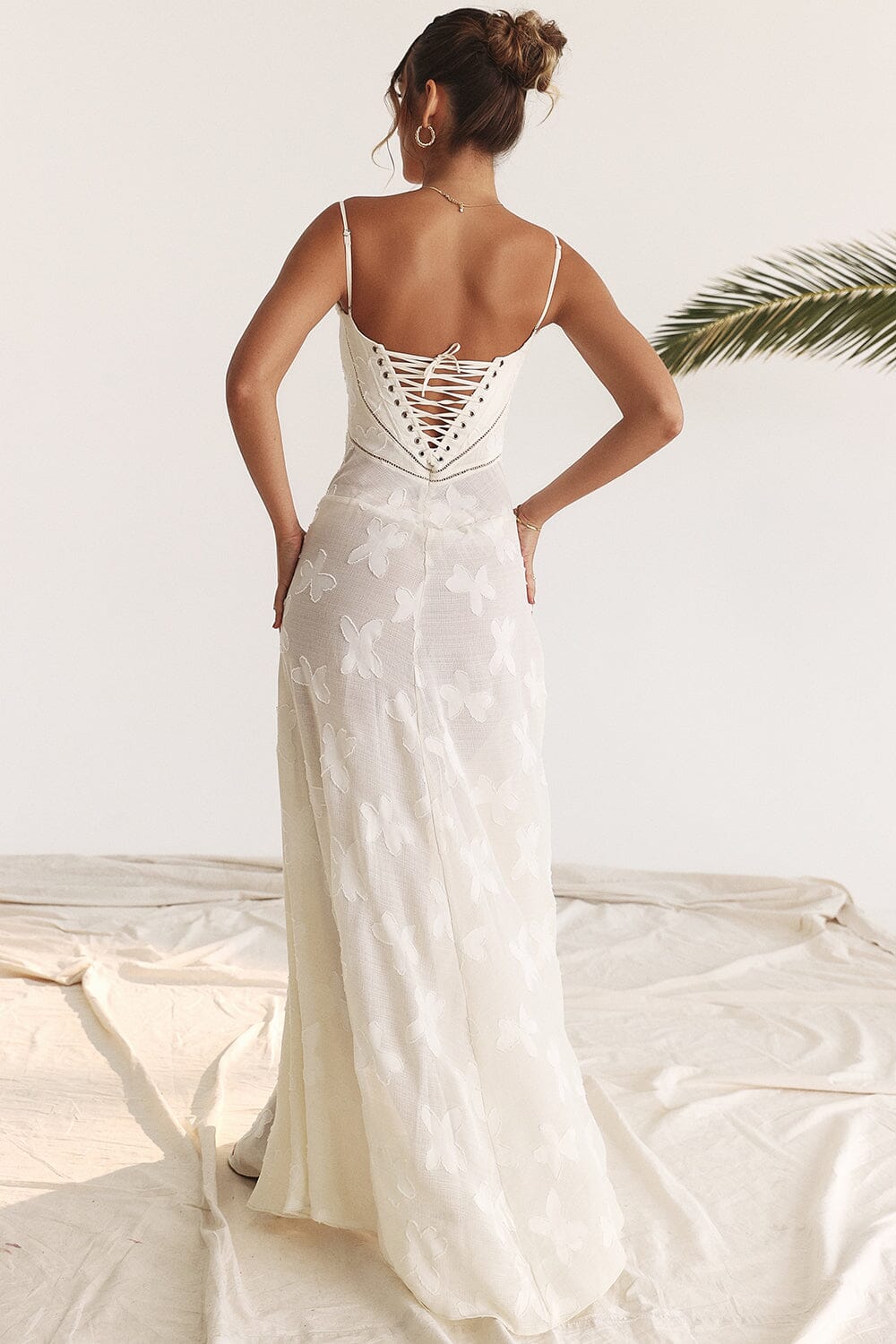 An elegant floor-length occasion dress in blush pink, styled for a formal wedding or gala event