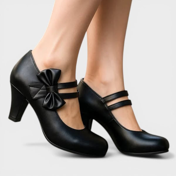 Women's mid-height heels in black with a soft delicate bow at the toe