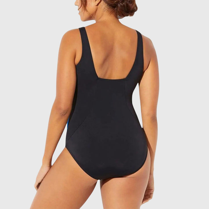 A woman wearing a figure-flattering swimsuit with a fresh summer print, relaxed by the pool.