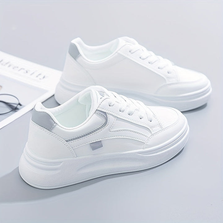 A woman in crisp white light comfort trainers paired with jeans.