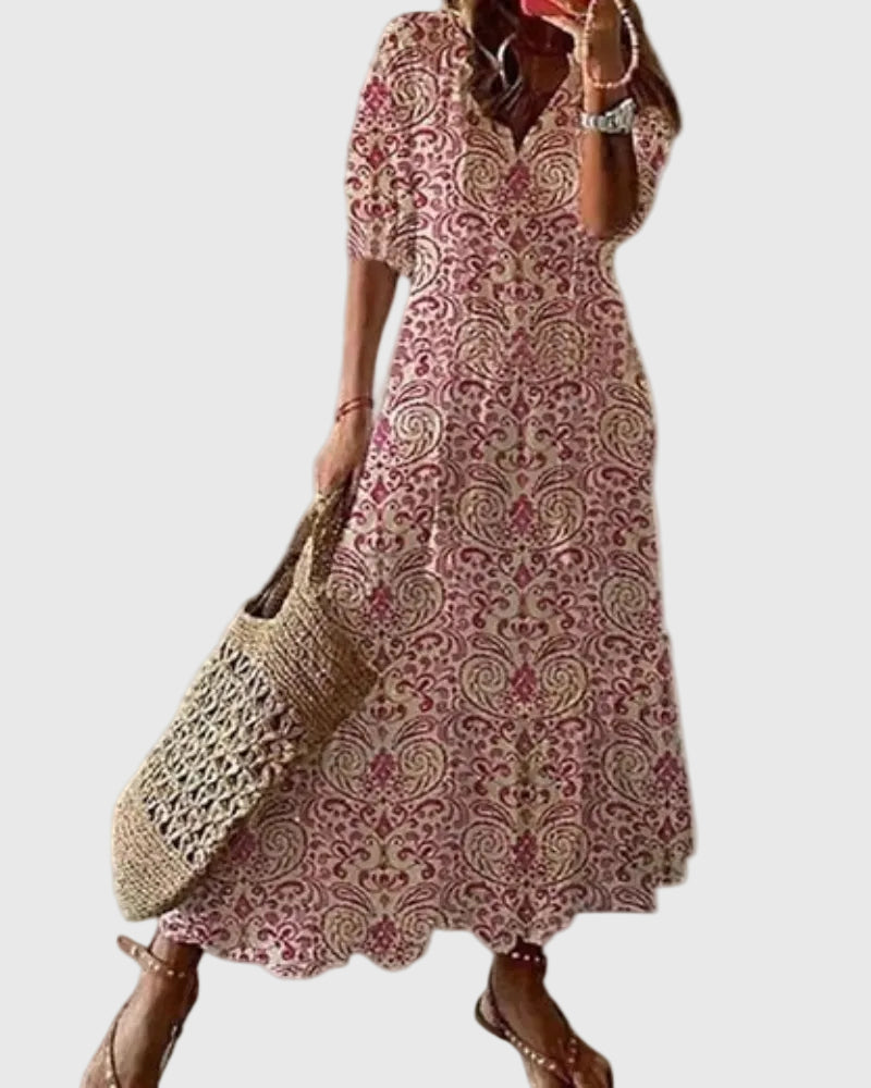 Woman wearing a long vintage-style boho maxi dress with delicate patterns and a fluttering V-neckline.