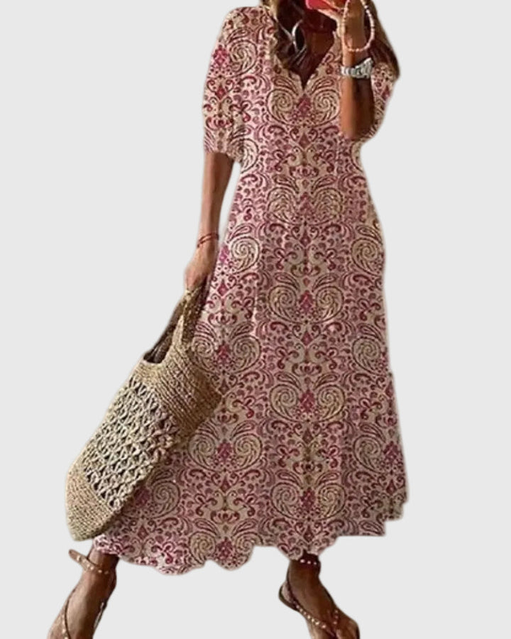 Woman wearing a long vintage-style boho maxi dress with delicate patterns and a fluttering V-neckline.