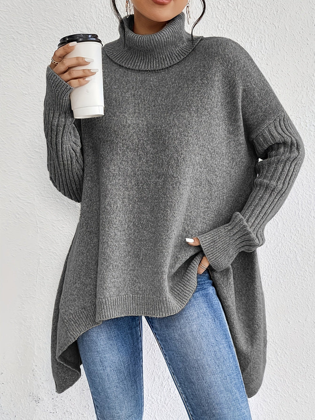 A woman wearing a stand-collar jumper with a chic asymmetric drape, warm and polished.