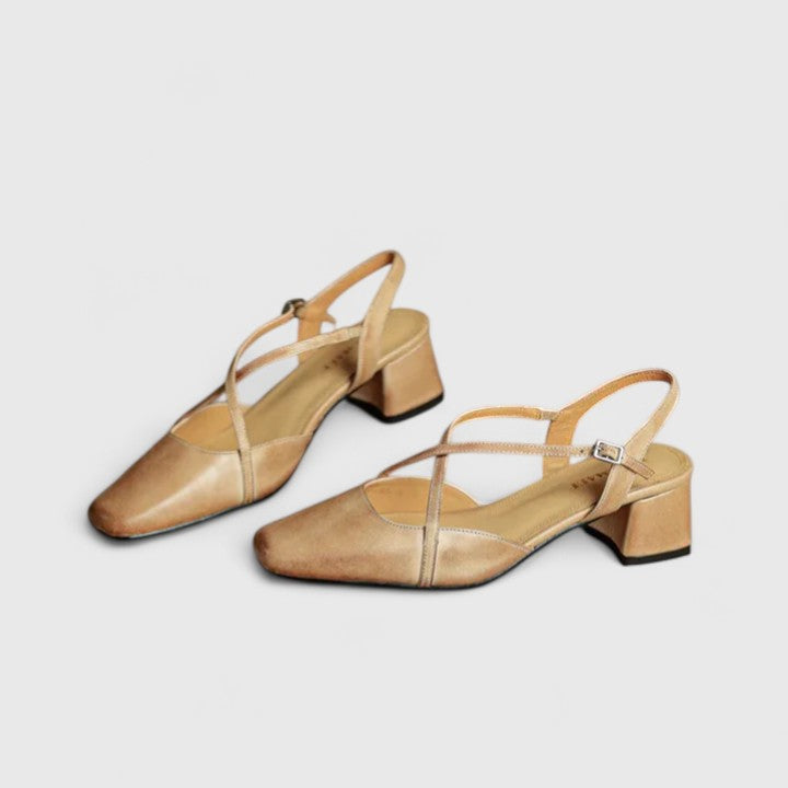 A woman wearing beige chic block heel sandals with an adjustable strap at an evening event.